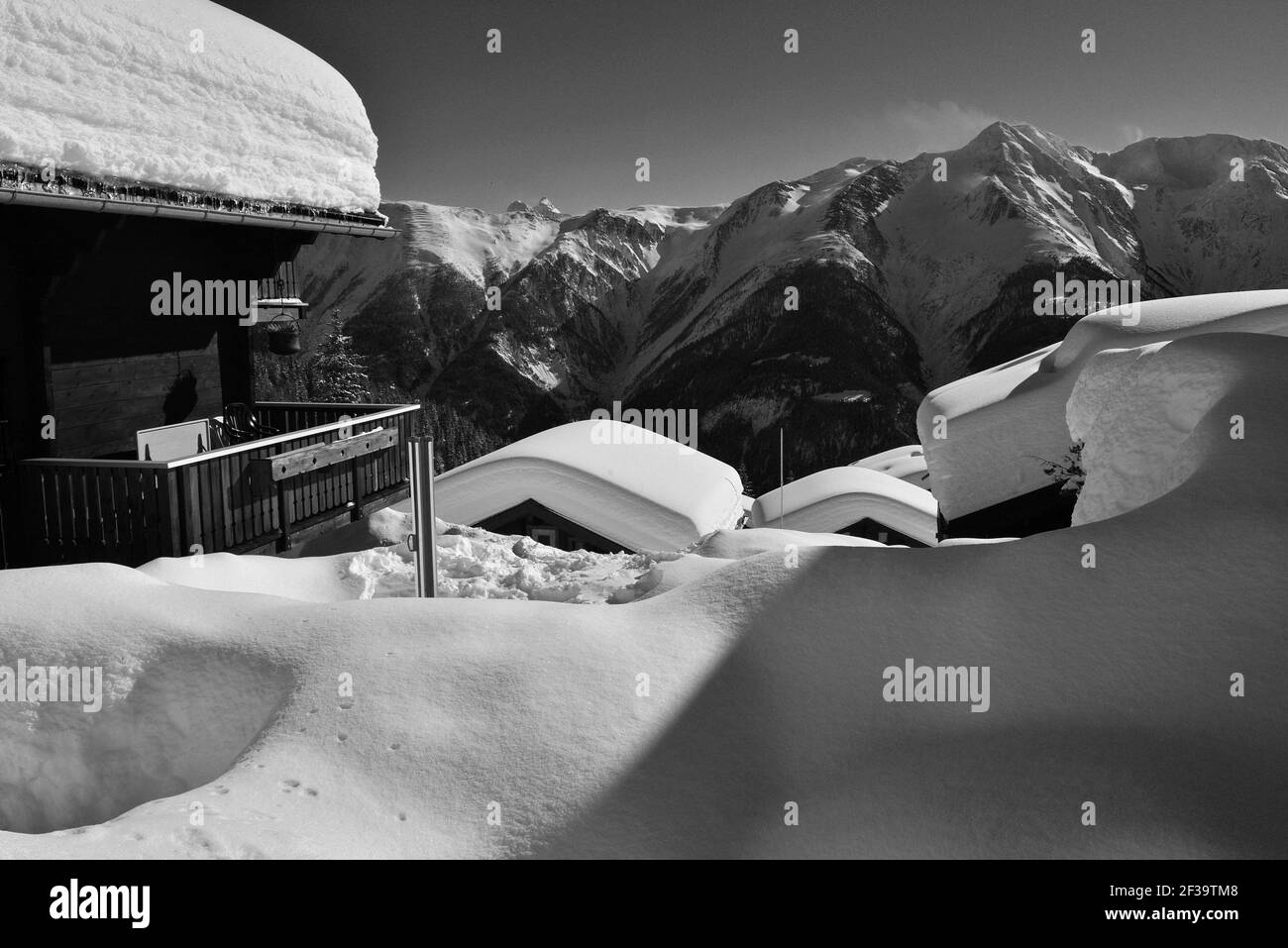 Monochrome de chalets avec une vue sous la neige profonde avec ciel bleu dans une station de ski Banque D'Images