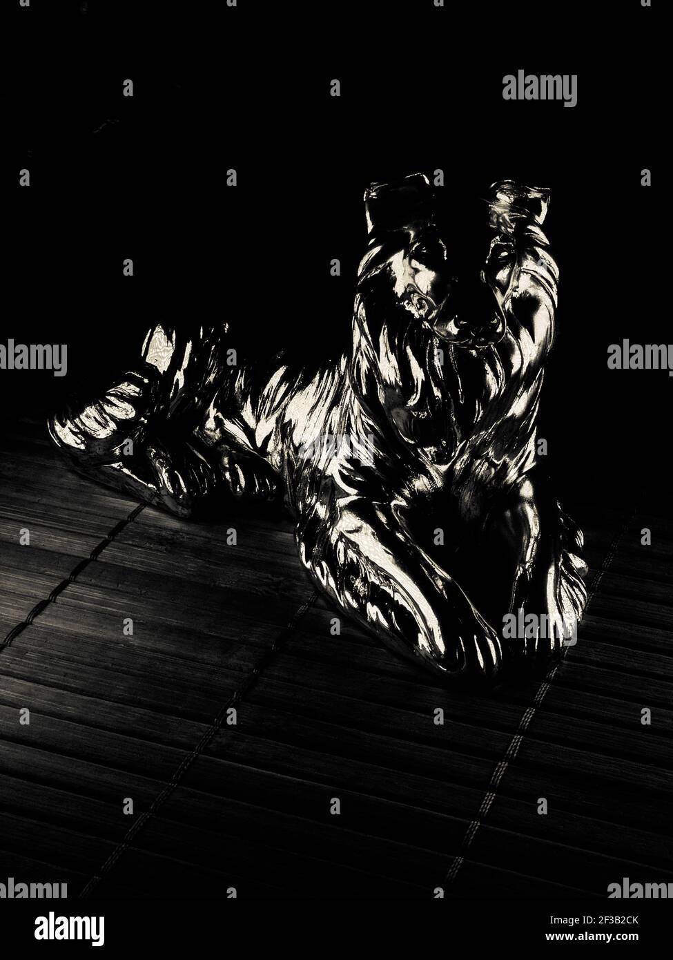 Statue en bronze d'un loup hurlant sur le côté du stand vue isolée sur fond blanc Banque D'Images