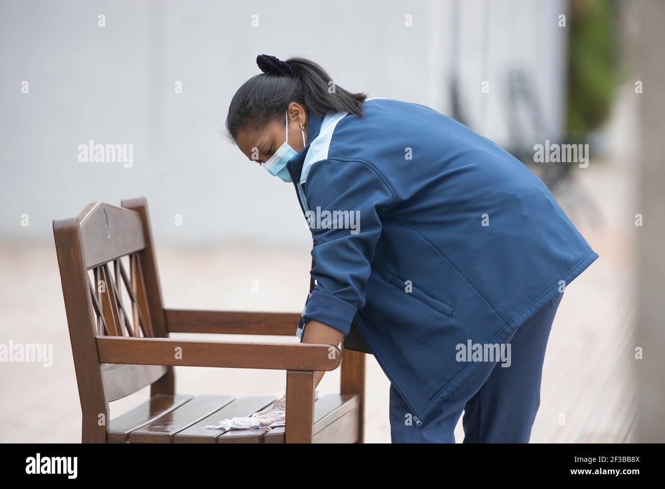 Femme de nettoyage avec banc d'essuyage de masque chirurgical avec lotion antiseptique à l'Open de France 2020, Paris, France, Europe Banque D'Images