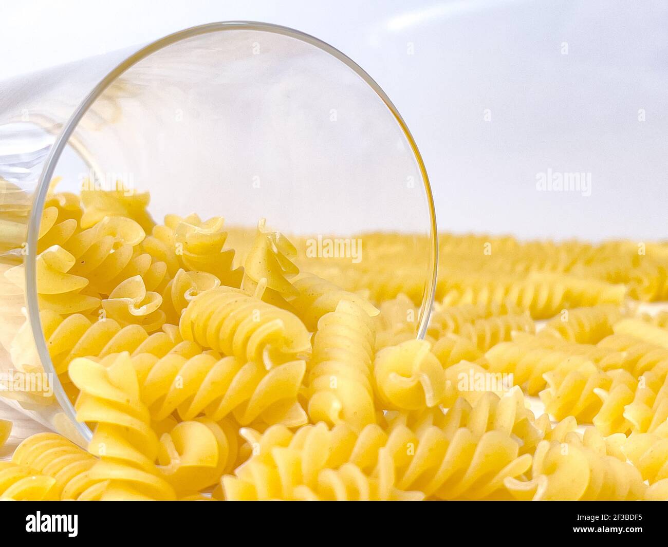 Pâtes italiennes sèches en forme de spirale en verre dans la cuisine. La nourriture. Macaroni non cuit. Banque D'Images