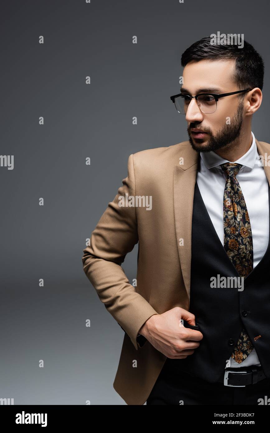 jeune homme arabe en blazer beige et gilet noir absent sur gris Photo Stock  - Alamy