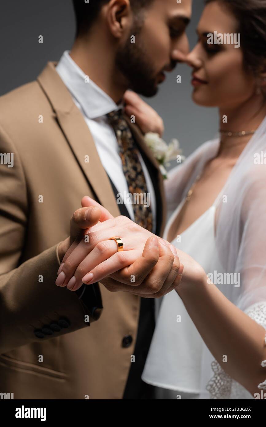 Bague de mariage sur le doigt de la mariée dansant avec le marié arabe sur  fond flou sur isolé sur gris Photo Stock - Alamy