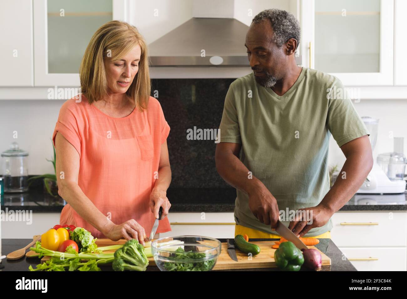 Divers couples âgés debout dans la cuisine et dîner de cuisine Banque D'Images