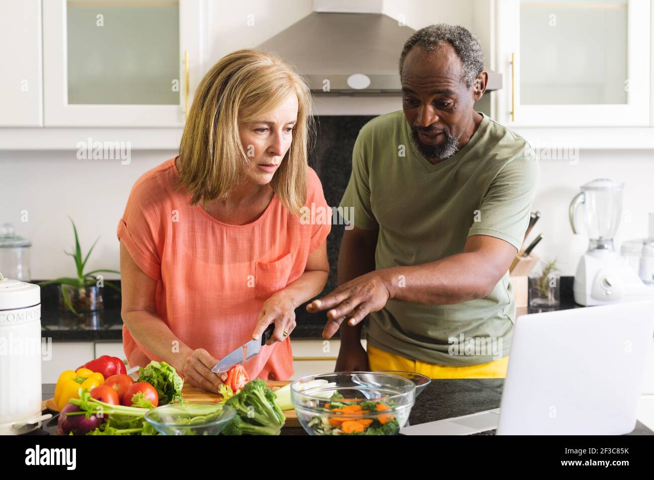 Divers couples âgés debout dans la cuisine et dîner de cuisine Banque D'Images