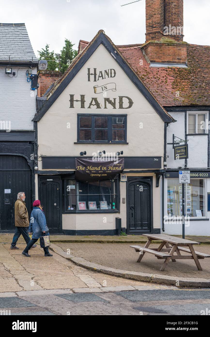 Un homme et une femme mûrs marchent à côté de la main dans le pub à High Street, Pinner, Middlesex, Angleterre, Royaume-Uni Banque D'Images