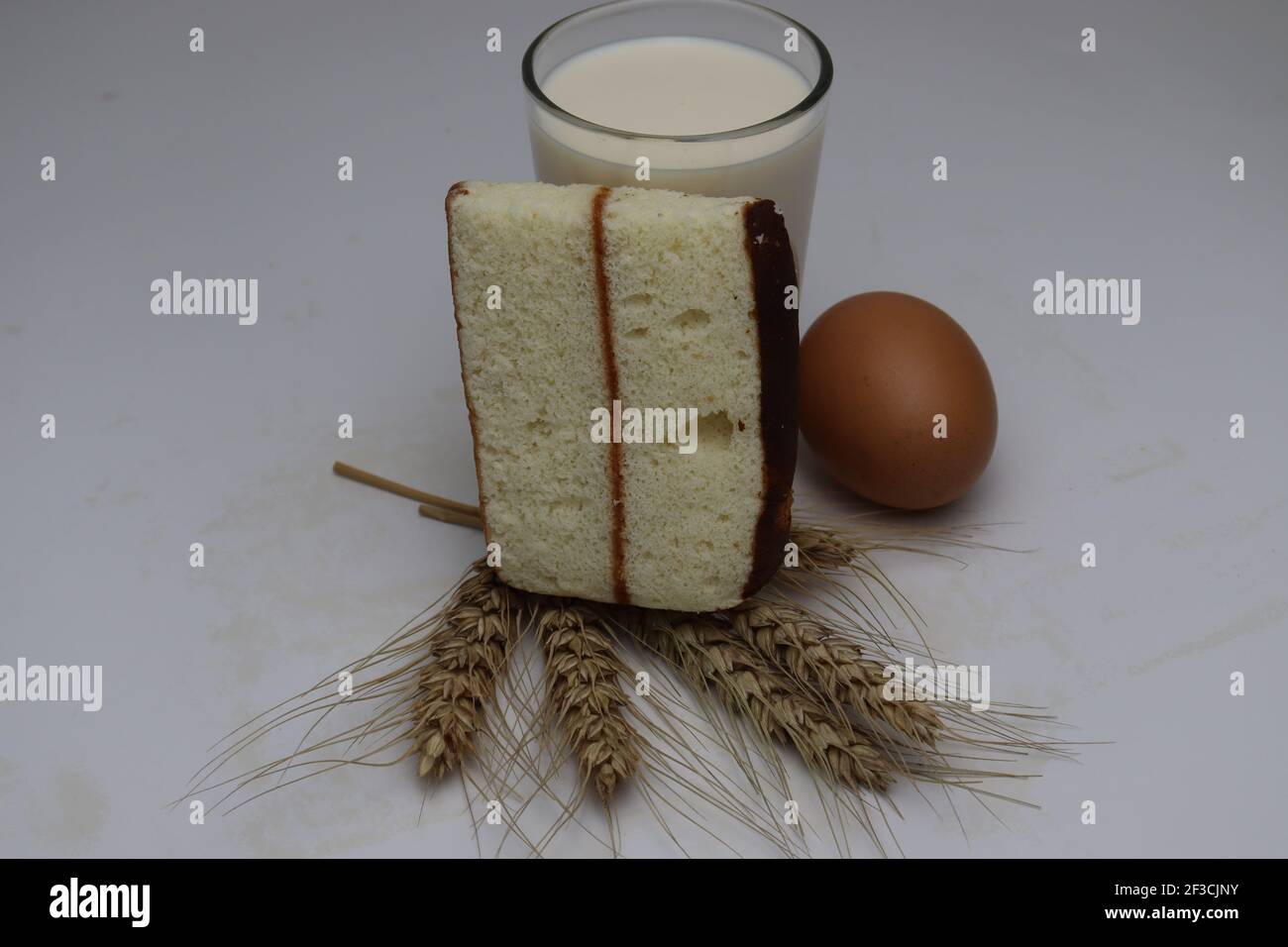 gâteau et blé mûr et oeuf et lait et atta sur fond blanc Banque D'Images