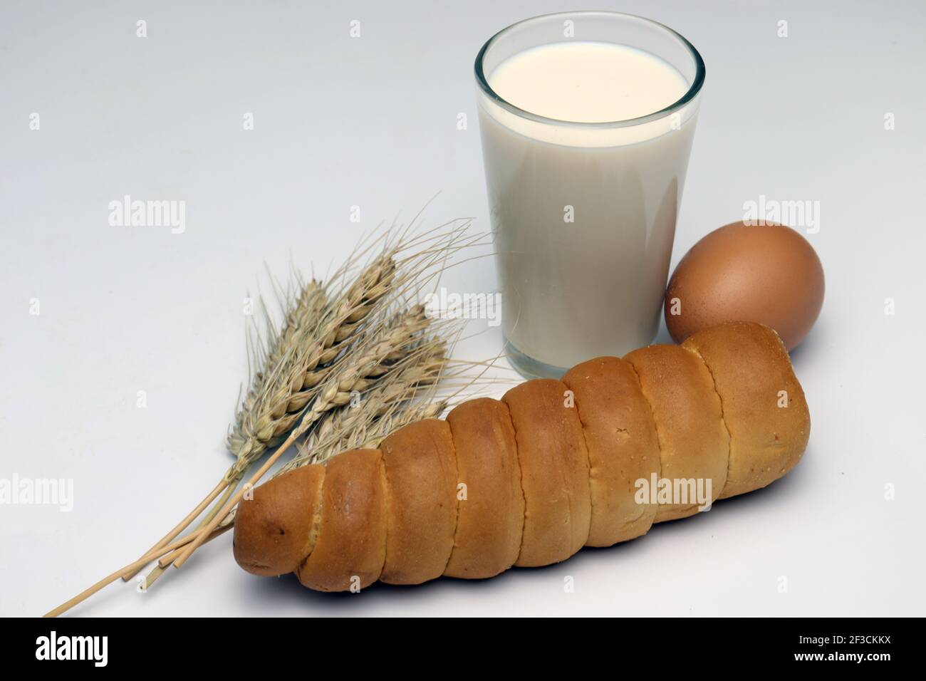 le rouleau de crème et le blé mûr et l'oeuf et le lait arrière-plan blanc Banque D'Images