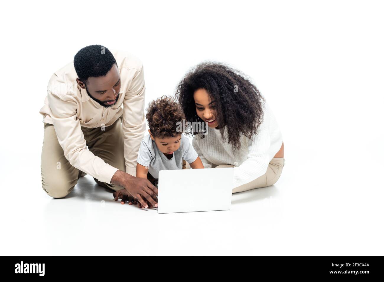 couple afro-américain utilisant un ordinateur portable avec un enfant en bas âge blanc Banque D'Images