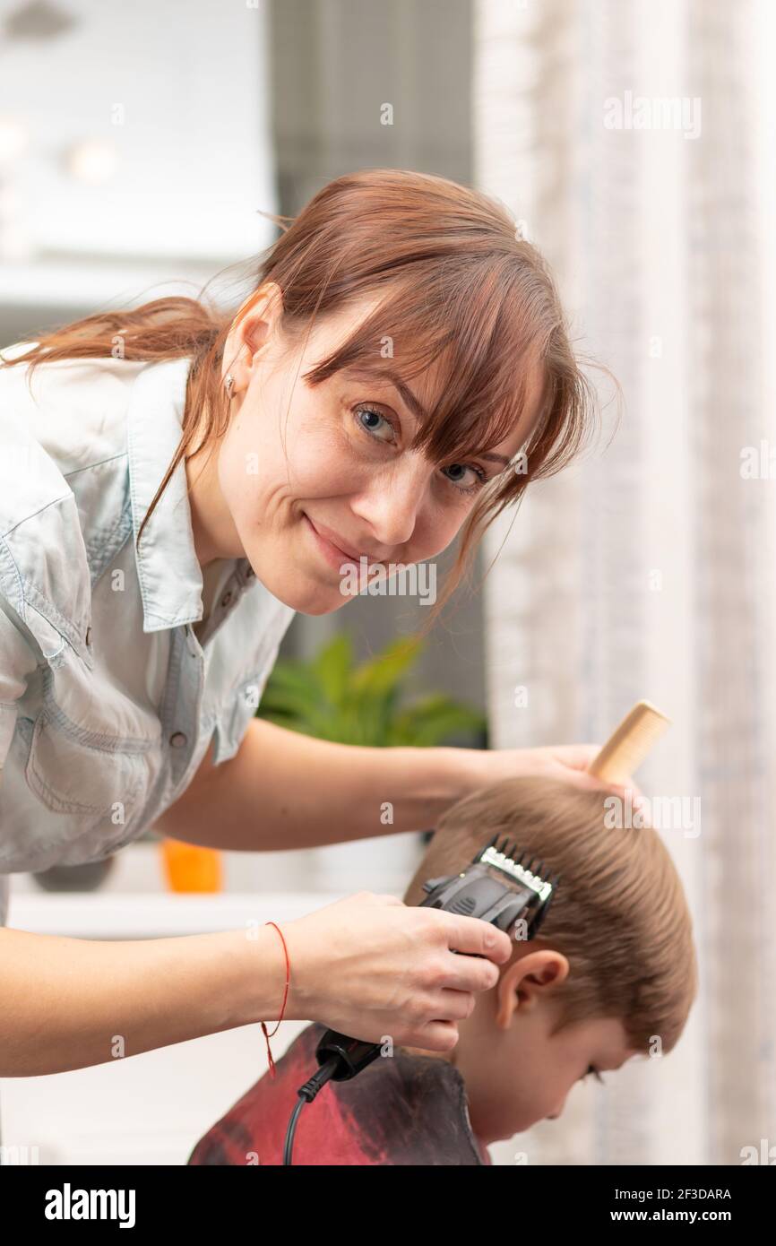Jeune Maman Coiffeur Coupe Son Bebe Garcon A La Maison Avec Une Tondeuse A Cheveux Pendant La Quarantaine Foyer Selectif Portrait Photo Stock Alamy