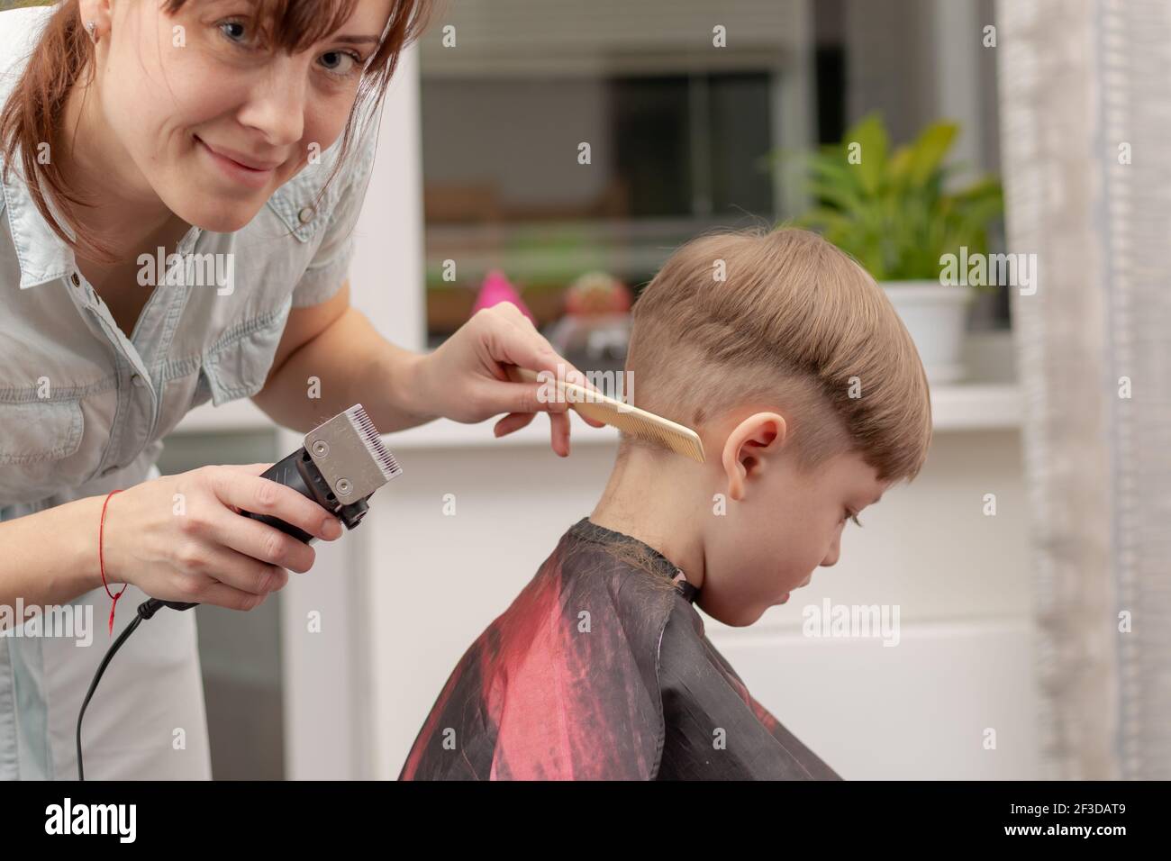 Jeune Maman Coiffeur Coupe Son Bebe Garcon A La Maison Avec Une Tondeuse A Cheveux Pendant La Quarantaine Foyer Selectif Portrait Photo Stock Alamy