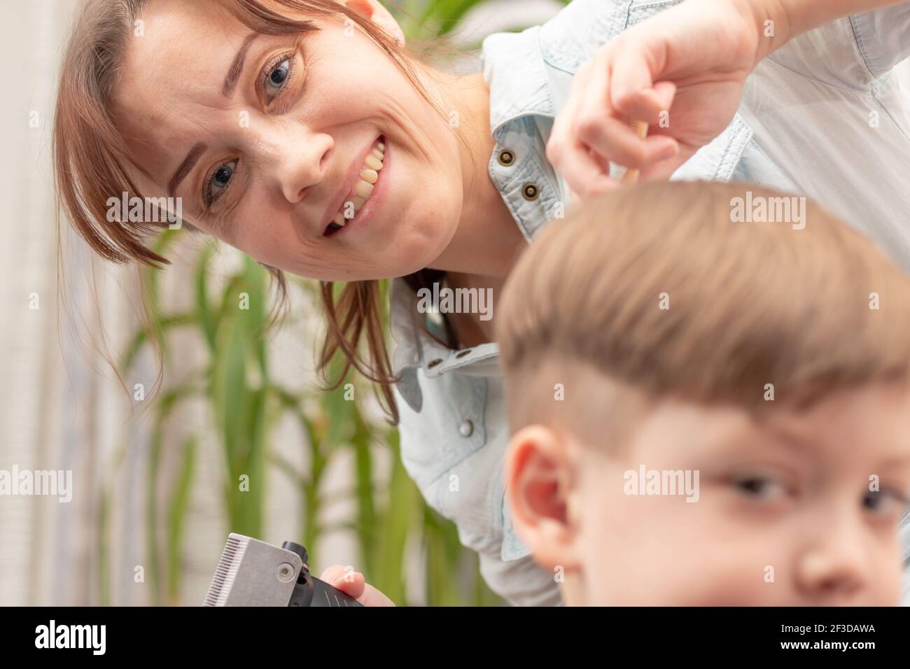 Jeune Maman Coiffeur Coupe Son Bebe Garcon A La Maison Avec Une Tondeuse A Cheveux Pendant La Quarantaine Foyer Selectif Portrait Photo Stock Alamy