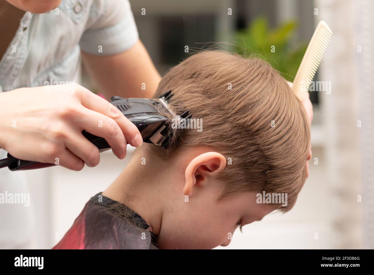 Jeune Maman Coiffeur Coupe Son Bebe Garcon A La Maison Avec Une Tondeuse A Cheveux Pendant La Quarantaine Foyer Selectif Portrait Photo Stock Alamy