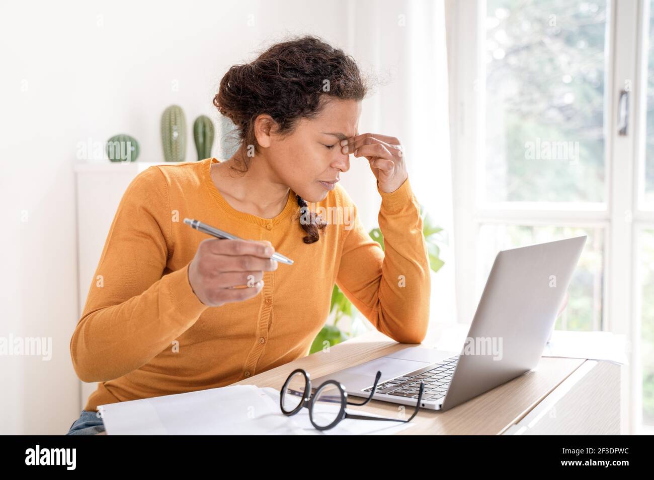 La femme noire souffre d'une fatigue oculaire et de maux de tête Banque D'Images