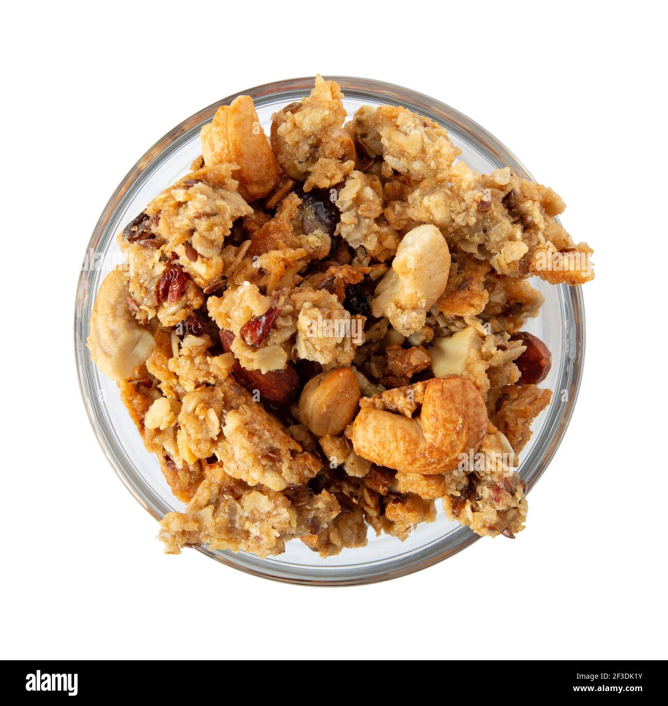Vue de dessus d'un petit bol en verre rempli de céréales complètes granola avec fruits et noix illuminés de lumière naturelle. Banque D'Images