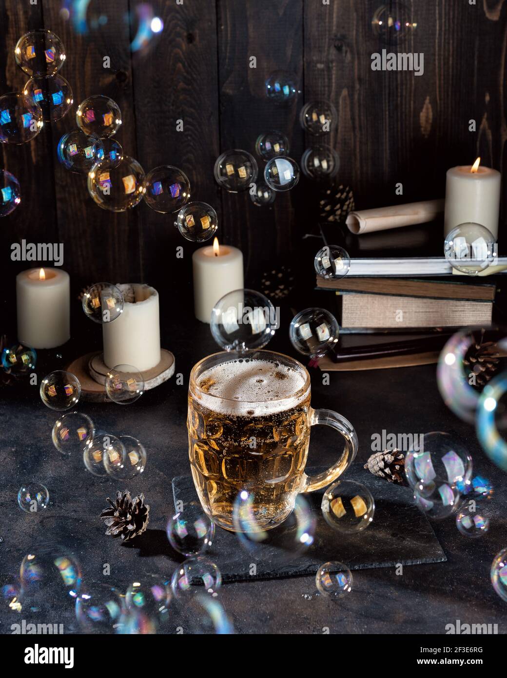 Une pinte de bière magique et des bougies sur un comptoir de bar sombre. Fête de pub de la Saint-Patrick Banque D'Images