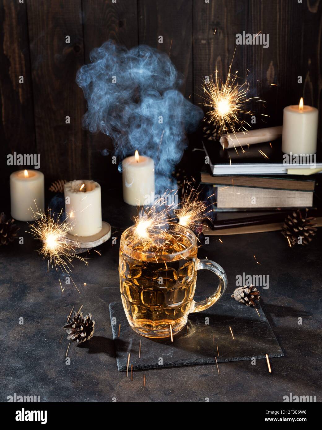 Une pinte de bière magique et des bougies sur un comptoir de bar sombre. Fête de pub de la Saint-Patrick Banque D'Images