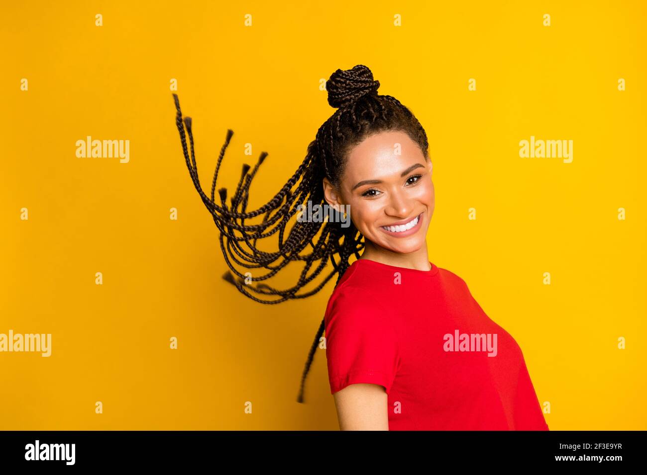 Portrait de profil de charmant sans souci peau sombre fille cheveux volant sourire éclatant isolé sur fond jaune Banque D'Images