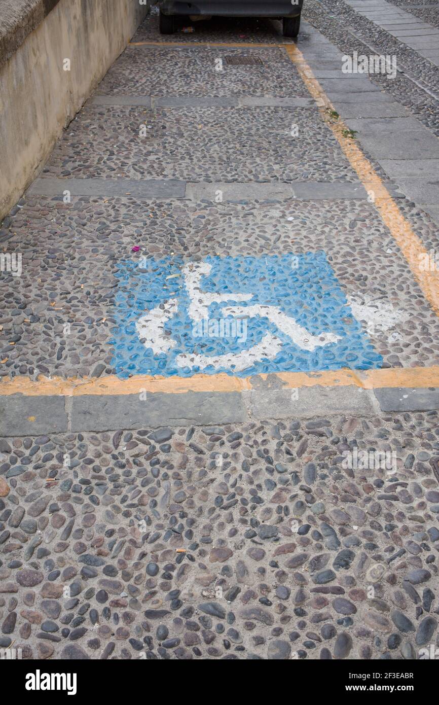 Place de parking pour personnes à mobilité réduite dans une rue pavée de  Sassari, ville de Sardaigne Italie Photo Stock - Alamy