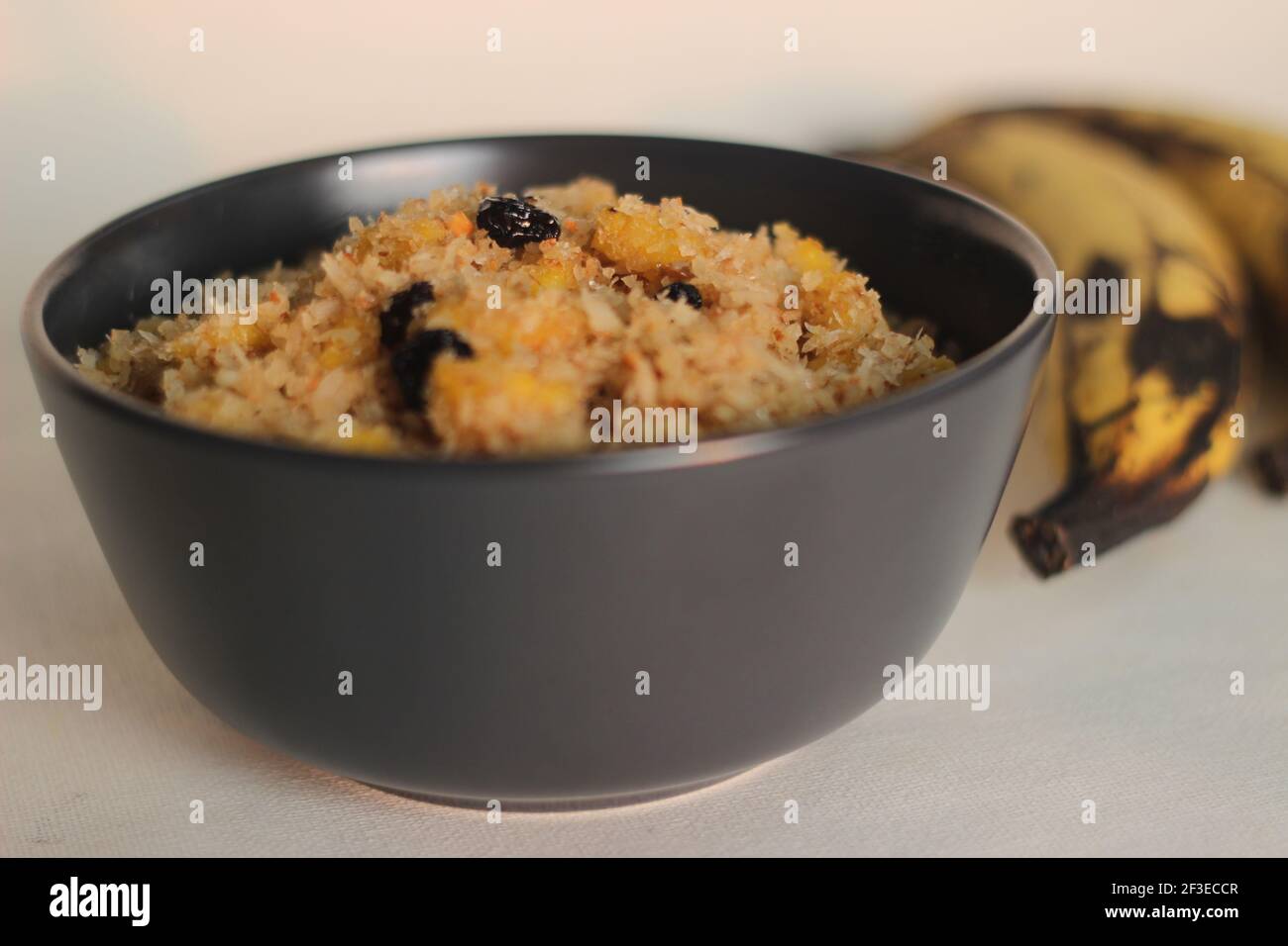 Mélange de raisins secs de noix de coco plantain préparé pour la fabrication de crêpes plantain ou de crêpes. Prise de vue sur fond blanc Banque D'Images