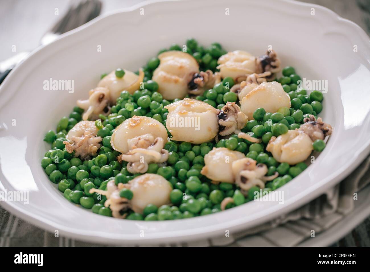 Seiches avec petits pois sur une assiette. Photo de haute qualité. Banque D'Images