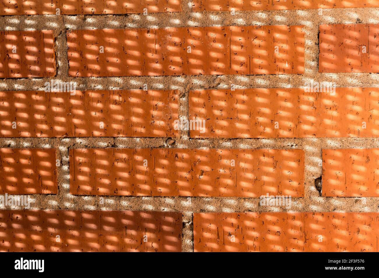 briques orange alignées sur béton sur la façade Banque D'Images