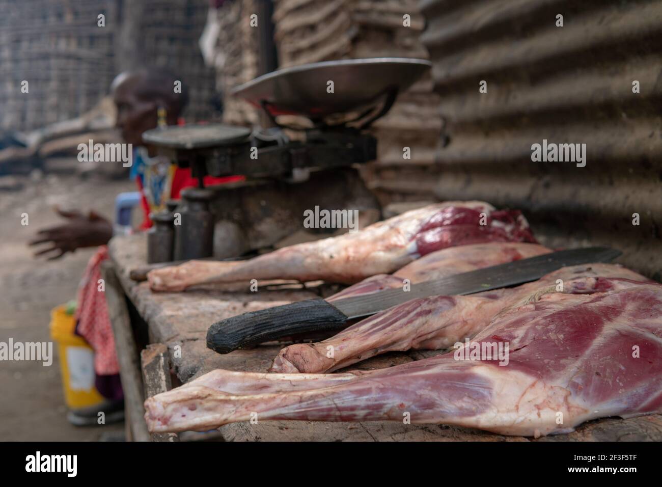 Engare Sero, Tanzanie - janvier 2020 : lieu de cuisine africaine dans le village de Masai. Chèvre jambes de viande fraîche et grand couteau de machette Banque D'Images