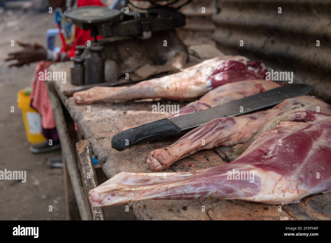 Cuisine africaine au village de Masai. Chèvre jambes de viande fraîche et grand couteau de machette Banque D'Images