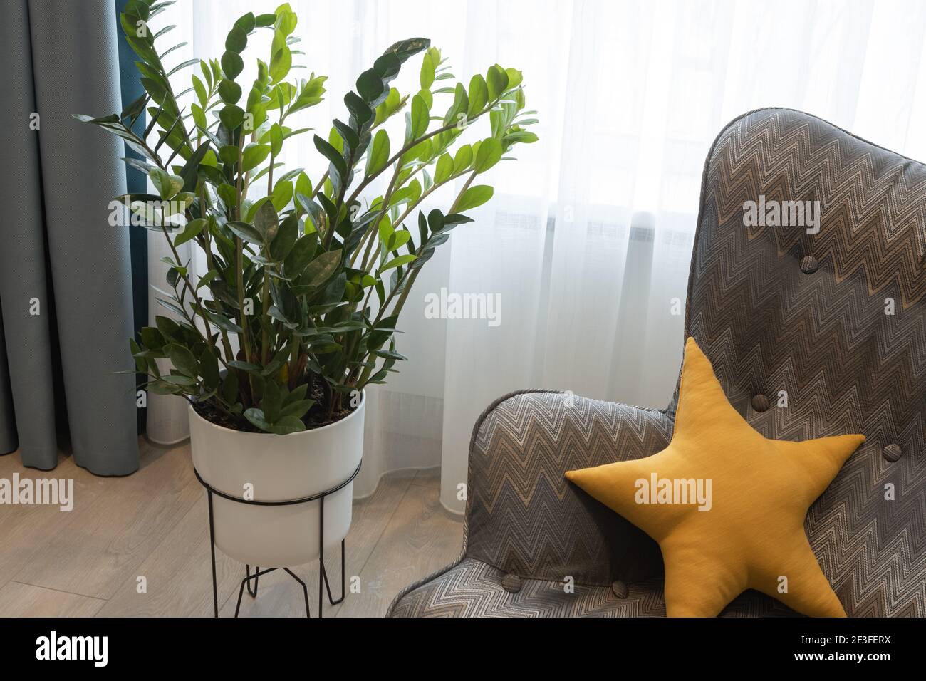 Intérieur moderne dans des couleurs neutres, détails. Fauteuil géométrique avec coussin en forme d'étoile, coin repos, plante en pot. Chambre d'enfant pour adolescent. Co Banque D'Images