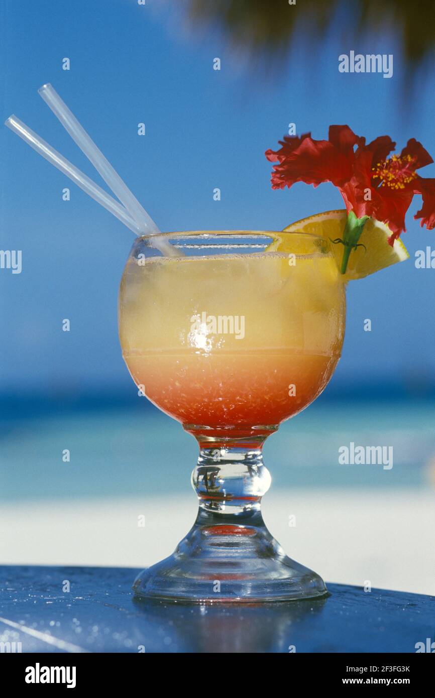 Punch au rhum, boisson tropicale avec fleur et fruits plage Banque D'Images