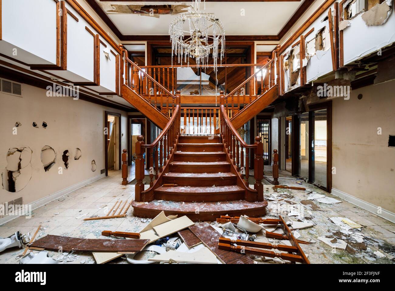 Un escalier de fantaisie qui a vu beaucoup de vandalisme intérieur d'un manoir abandonné Banque D'Images