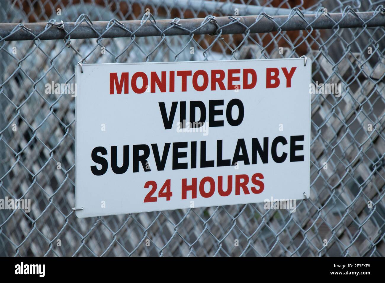 Vue de l'affiche surveillée par surveillance vidéo 24 heures ci-jointe à la clôture Banque D'Images