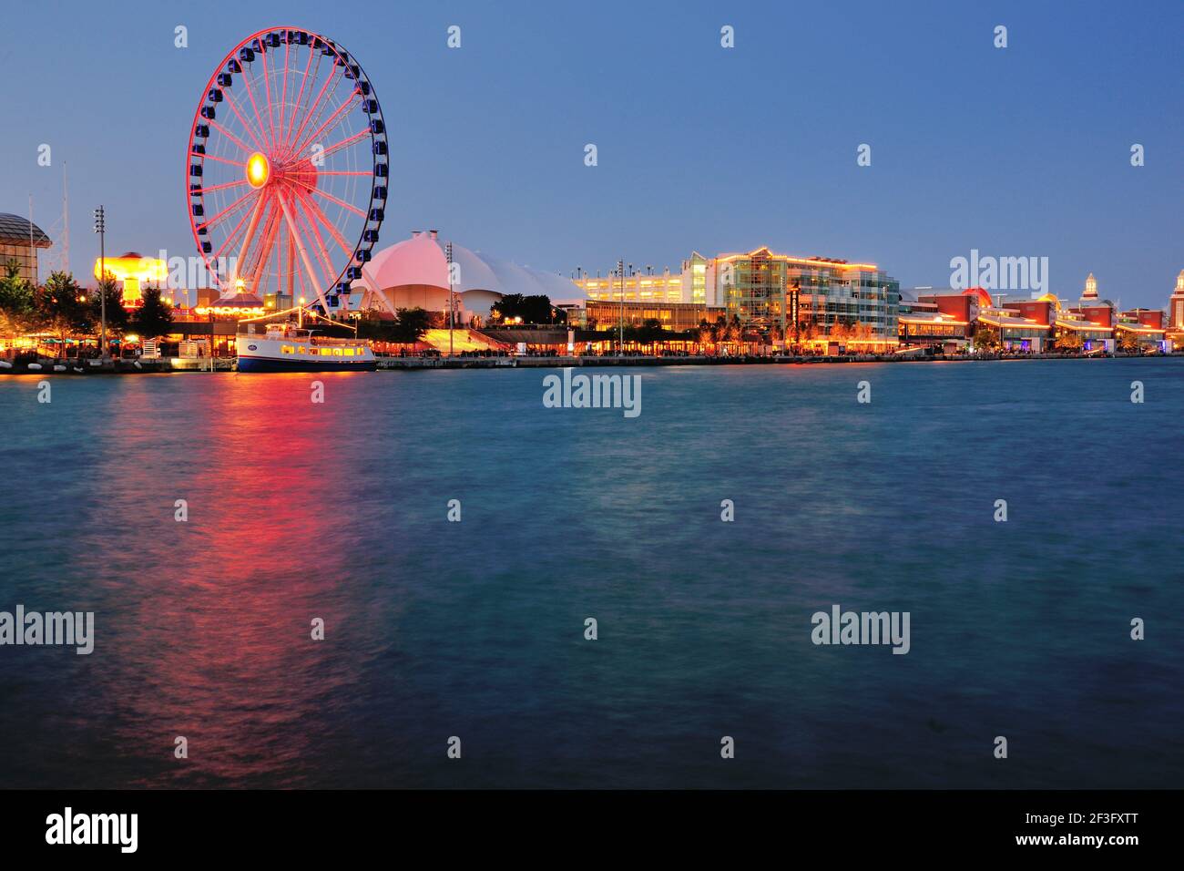 Chicago, Illinois, États-Unis. Navy Pier pendant que la nuit tombe sur la ville tandis que la roue du centenaire se reflète dans le port adjacent. Banque D'Images