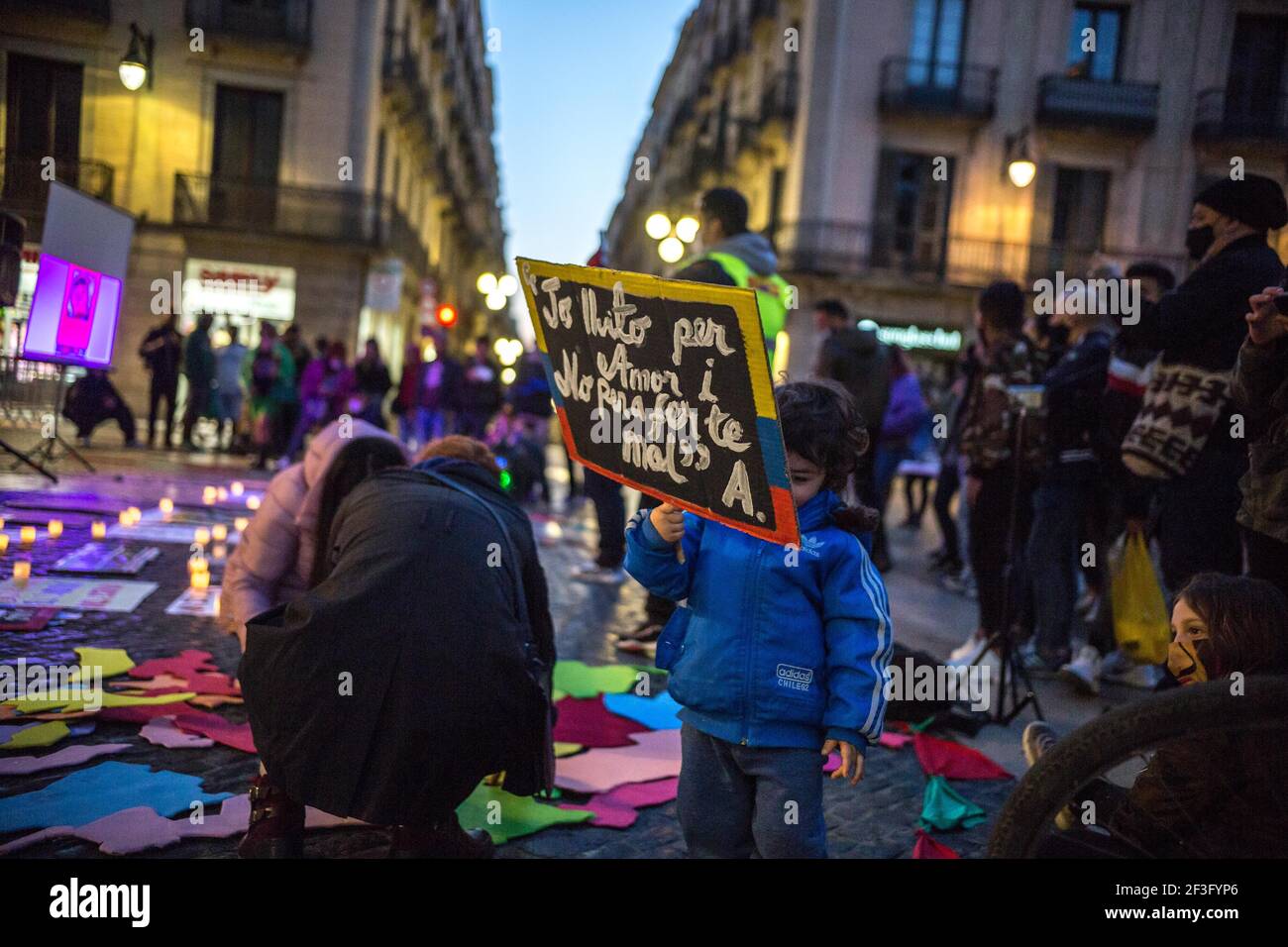 Un enfant tient un écriteau qui dit, je lutte pour l'amour et de ne pas vous blesser pendant la manifestation.représentants à Barcelone du groupe colombien, les mères de faux positifs de Soacha et Bogotá (MAFAPO), une association composée de mères, de femmes, Filles et sœurs d'hommes tués par des soldats de l'Armée nationale colombienne de manière illégitime et présentés comme des guérilleros tués au combat entre 2006 et 2009, sous le gouvernement d'Álvaro Uribe Vélez, Ils ont organisé une manifestation à Barcelone pour demander justice et à la mémoire des 6,402 personnes qui ont été victimes de ce phénomène dans le c Banque D'Images