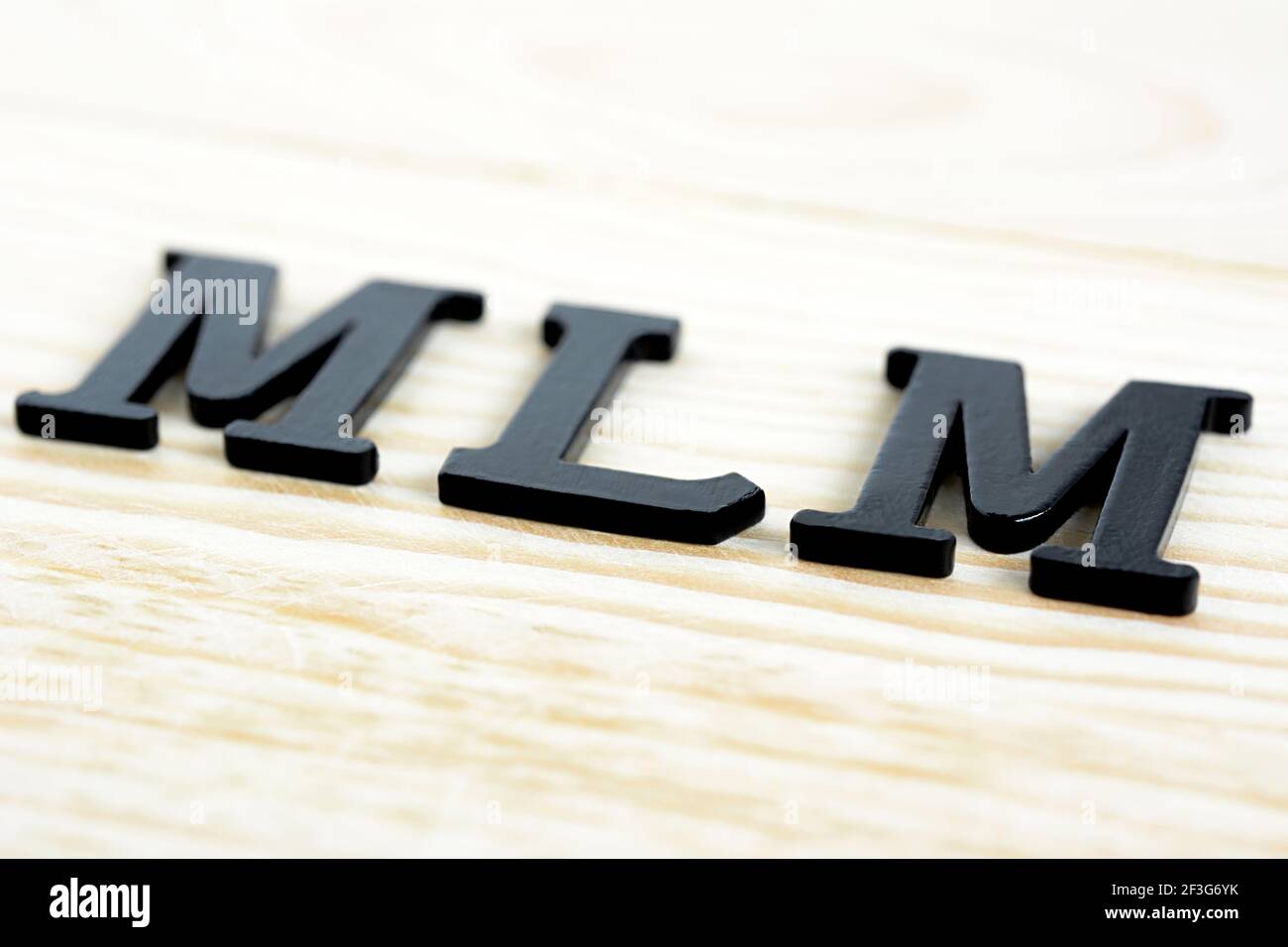 MLM (ou Multi-Level Marketing) chantent sur fond de bois Banque D'Images
