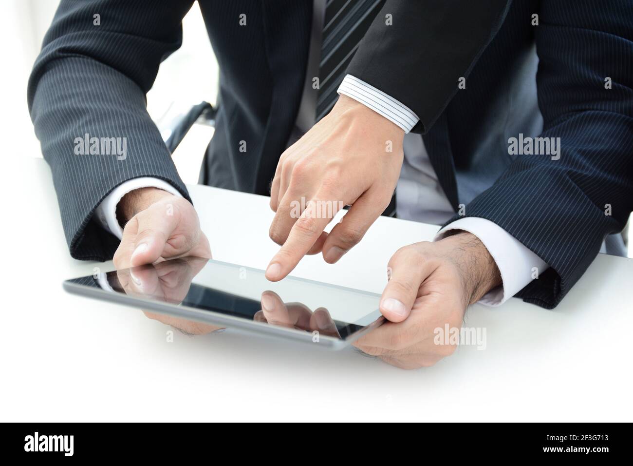 Deux hommes d'affaires utilisant une tablette informatique avec une main écran tactile - concept de discussion d'affaires Banque D'Images