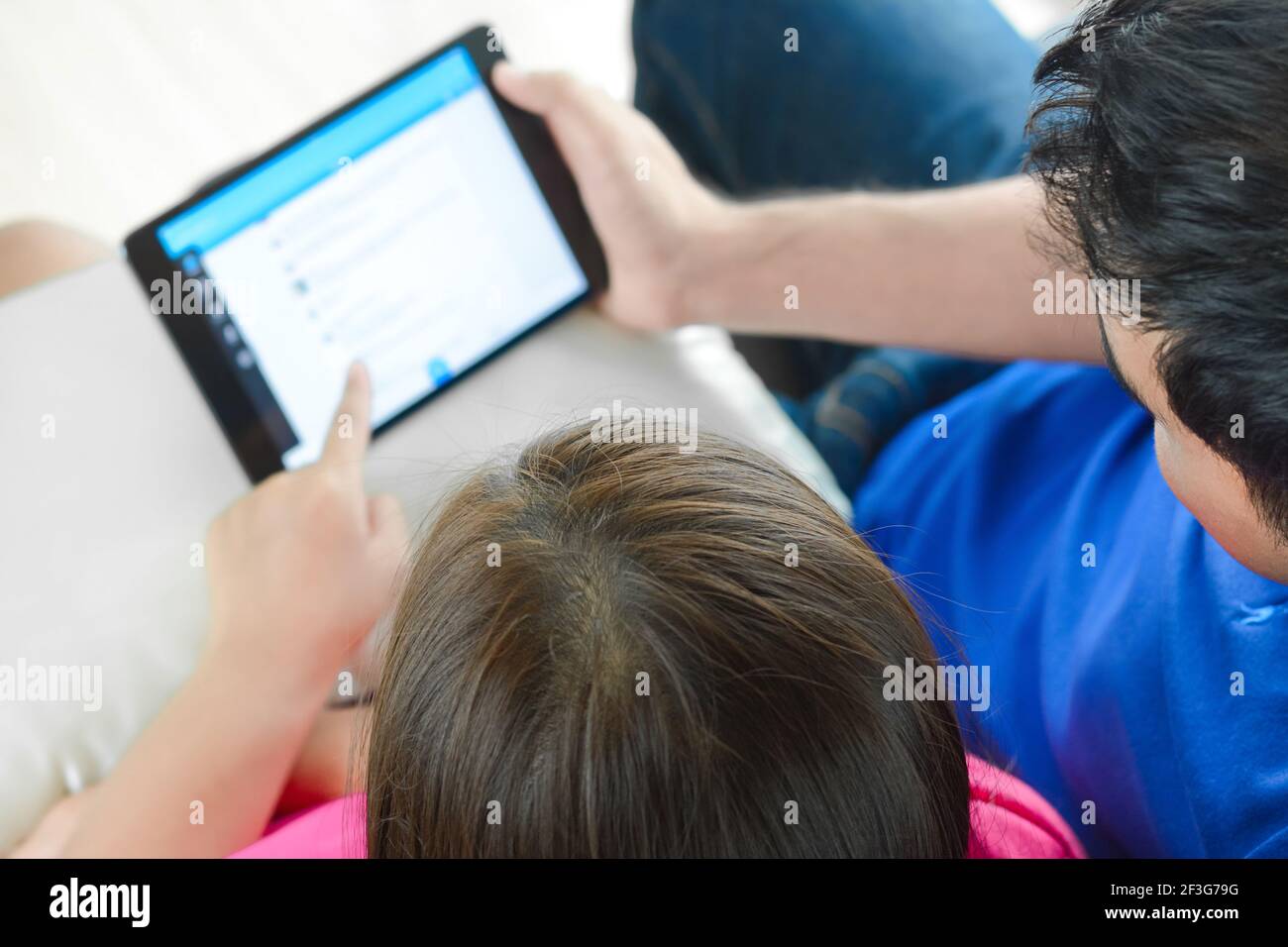 Couple regardant ensemble une tablette tout en étant assis sur le table - vue de dessus Banque D'Images