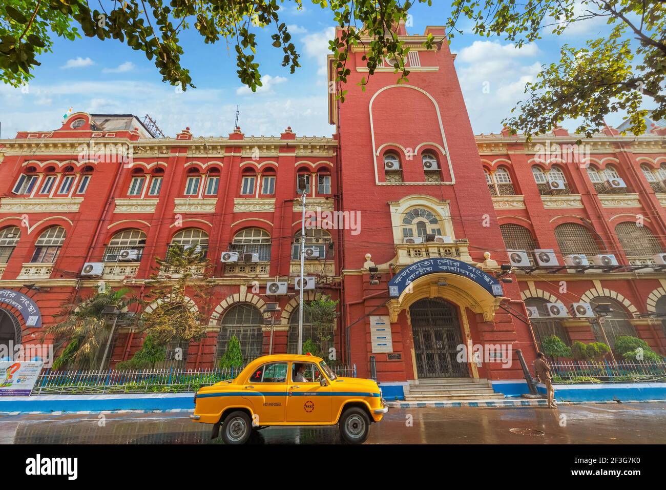 Taxi jaune devant le bâtiment de la Government Municipal Corporation construit dans le style de l'architecture coloniale à Kolkata, en Inde Banque D'Images