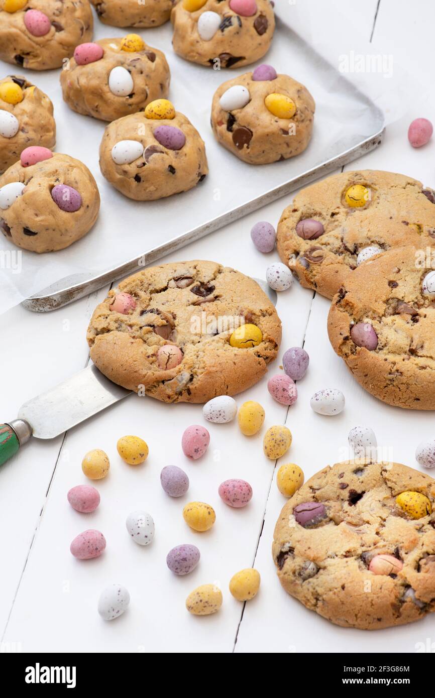 Petits biscuits aux œufs faits maison au chocolat et pâte à biscuits crue sur une plaque de cuisson Banque D'Images