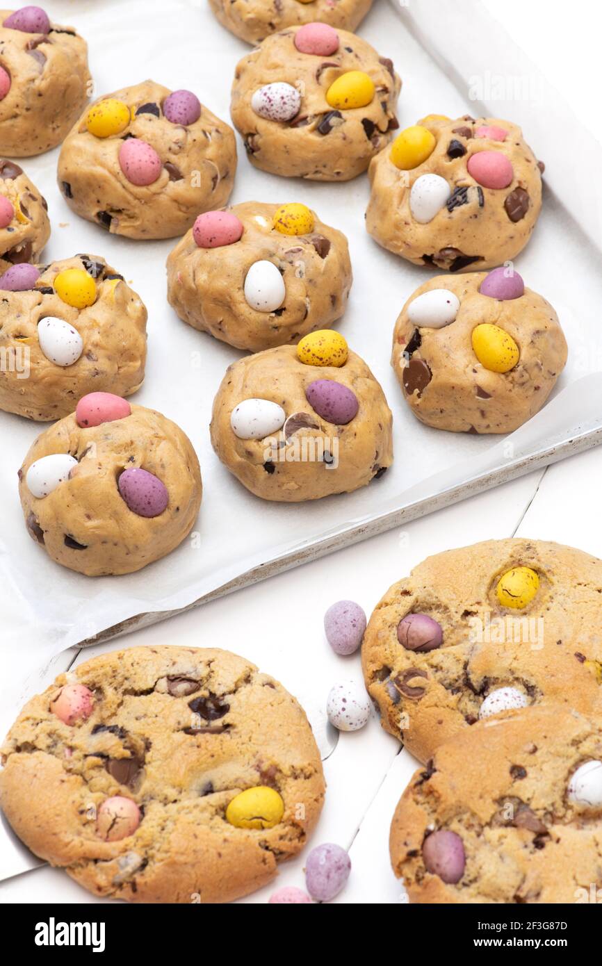 Petits biscuits aux œufs faits maison au chocolat et pâte à biscuits crue sur une plaque de cuisson Banque D'Images