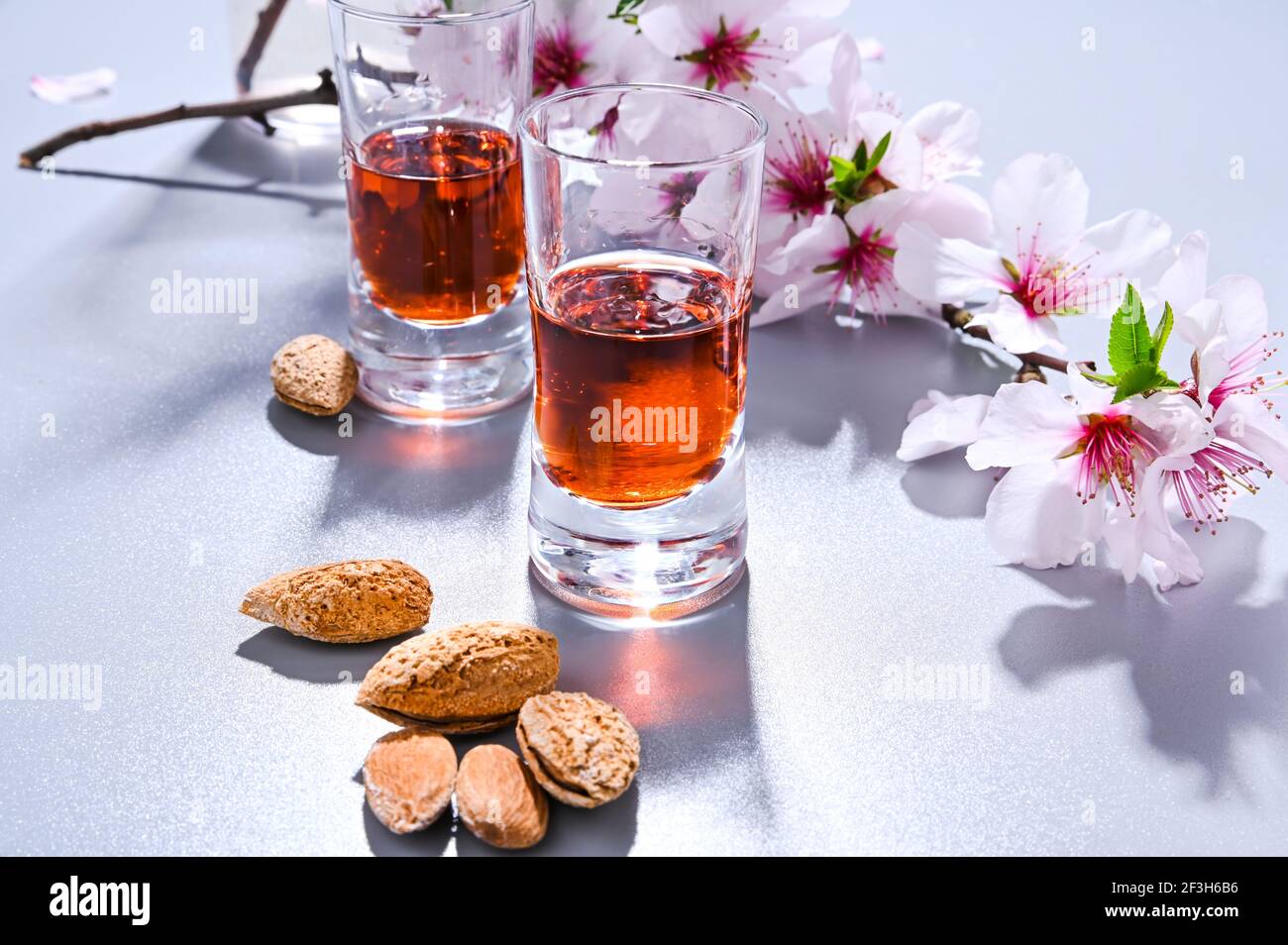 liqueur d'amande. La boisson traditionnelle forte en italie pour compléter le dîner est une liqueur à base de noix et de baies. Ratafia, alcool en grenaille. Vue de dessus sur la table et amandes en fleurs. Copier l'espace Banque D'Images