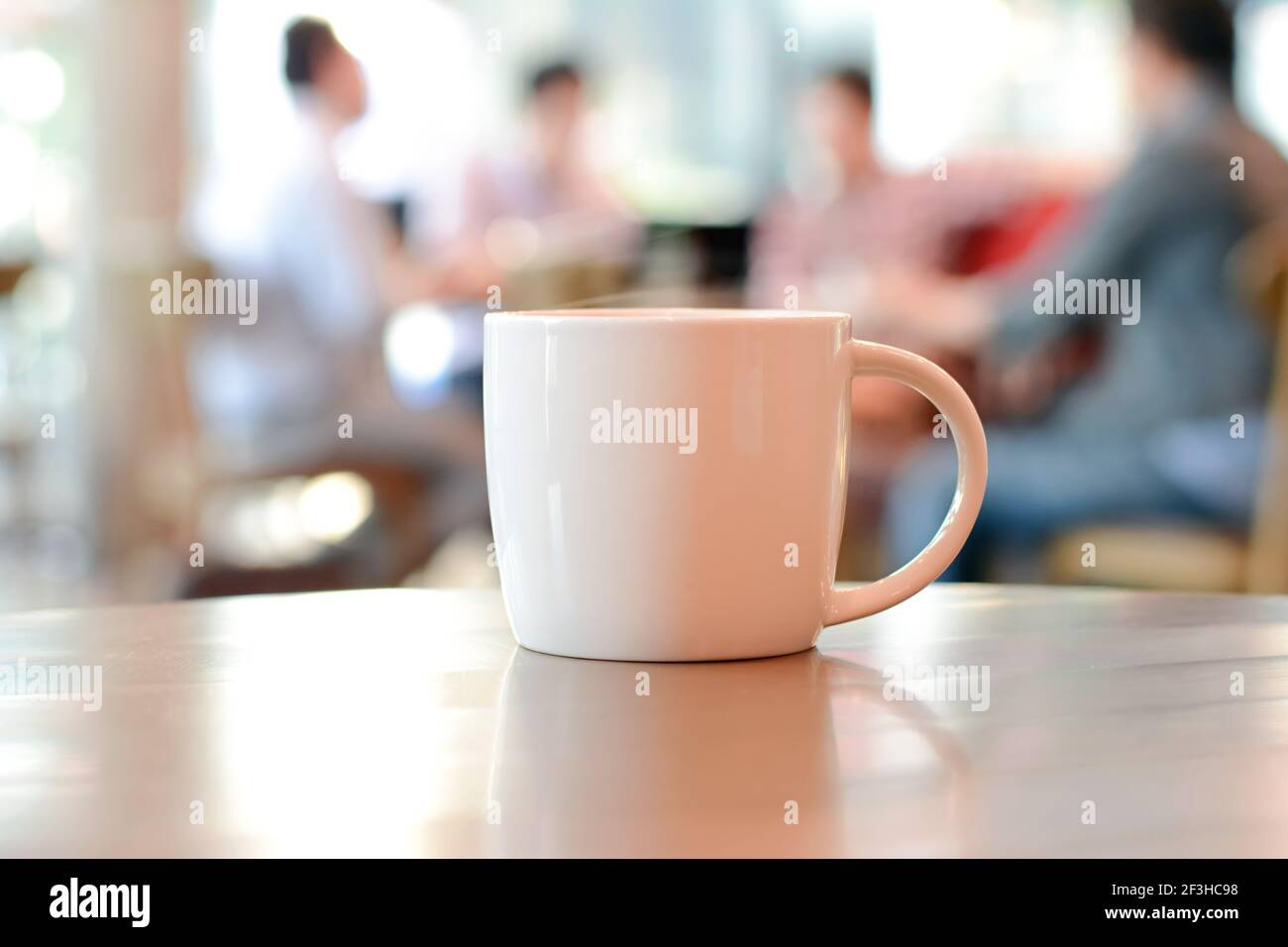 Une tasse de café sur la table avec des personnes dans le café-restaurant comme arrière-plan flou Banque D'Images