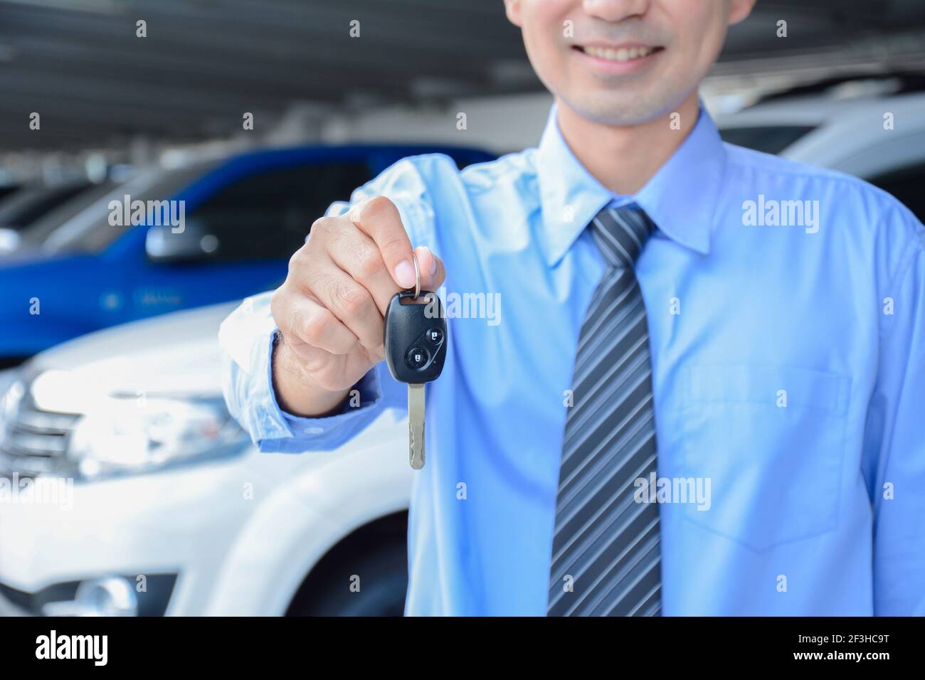 Homme d'affaires donnant une clé de voiture - vente de voiture, location et concepts d'assurance Banque D'Images