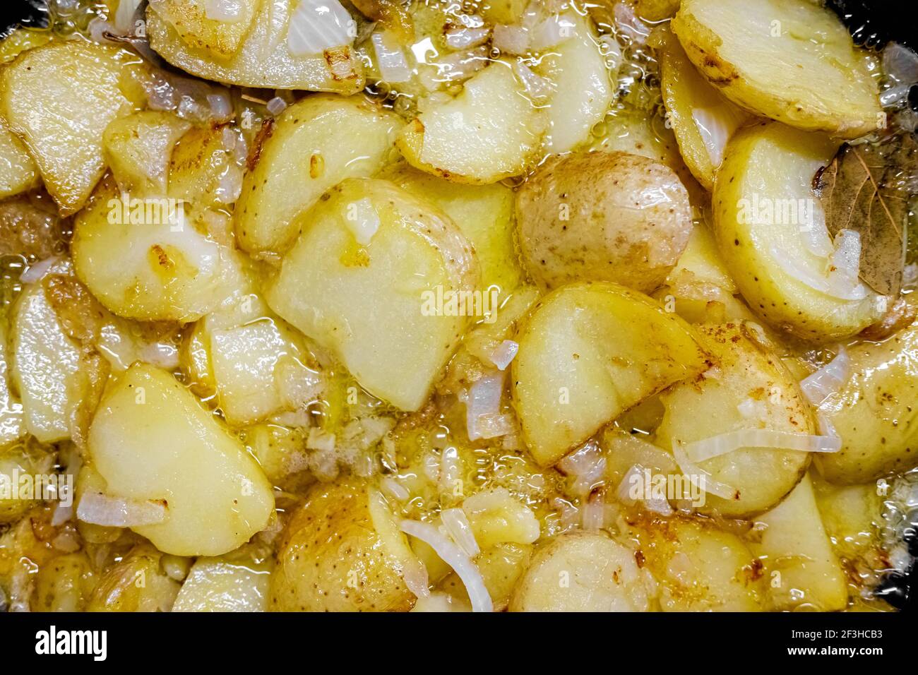 Plat espagnol typique à base de pommes de terre et d'ail, poêlé dans une casserole avec de l'huile d'olive, vu d'en haut Banque D'Images