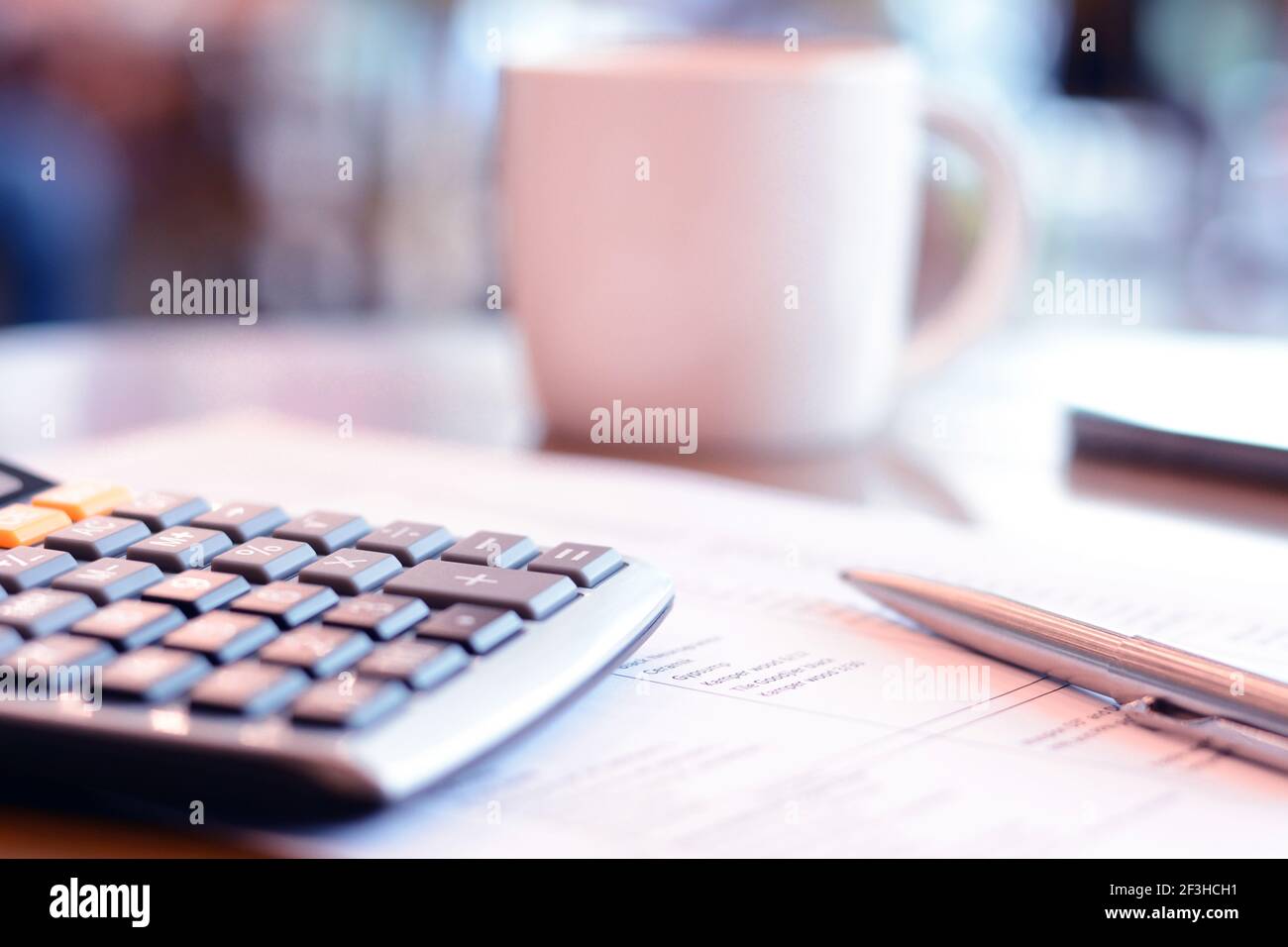 calculatrice et stylo sur papier sur la table avec flou fond de la tasse à café Banque D'Images