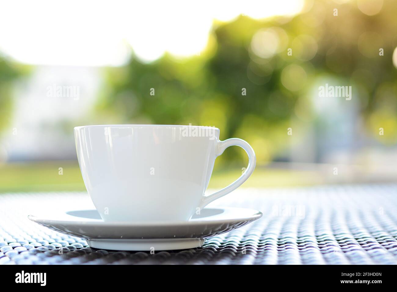 Tasse à café sur la table avec fond vert et flou Banque D'Images