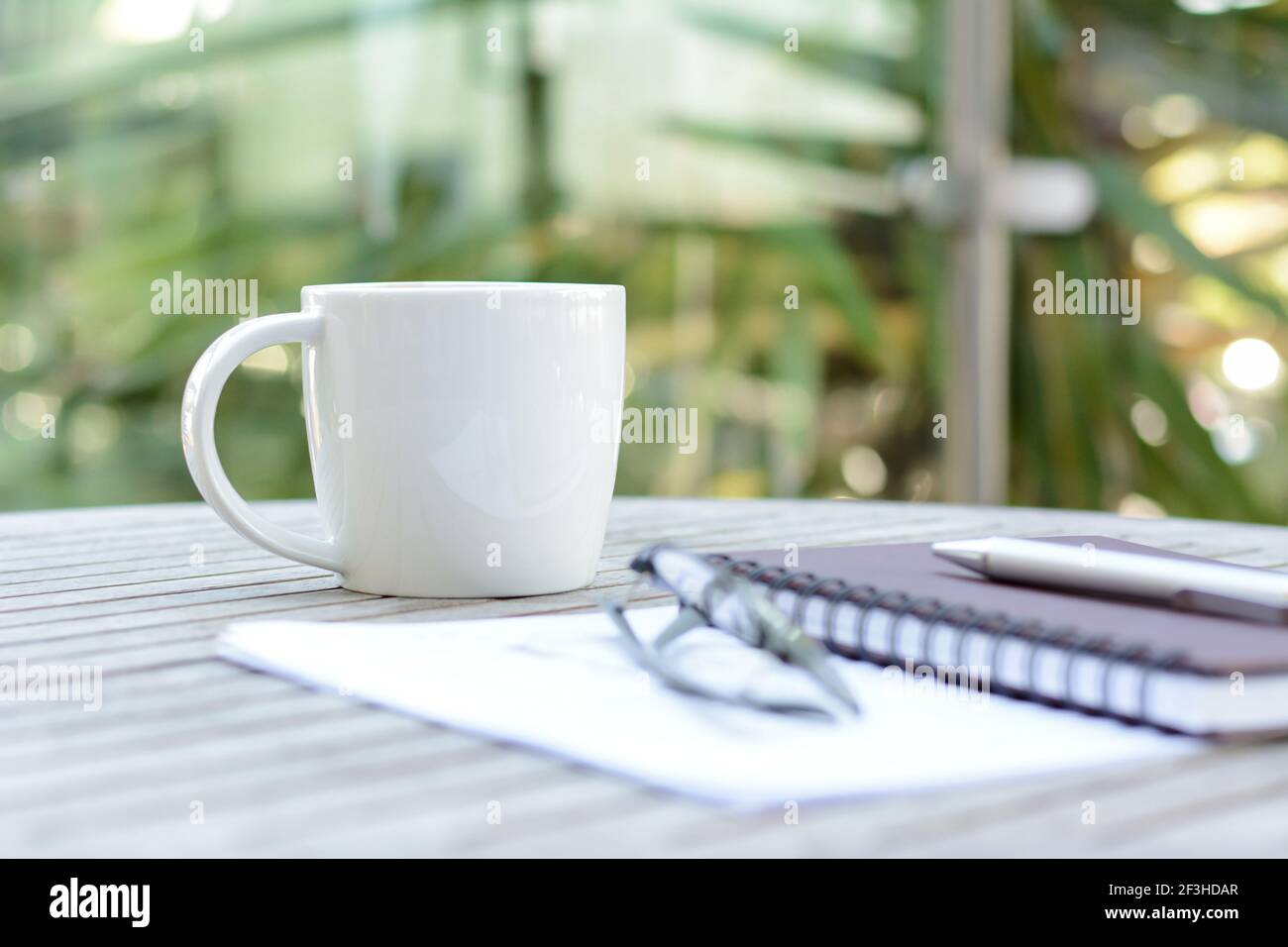 Tasse à café sur table en bois avec carnet, stylo et lunettes Banque D'Images