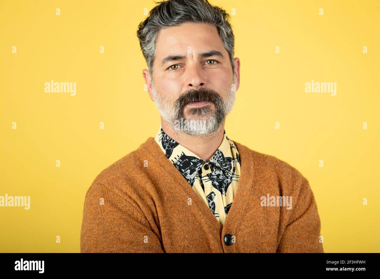 Photo d'un homme mature, isolé sur fond de mur jaune Banque D'Images