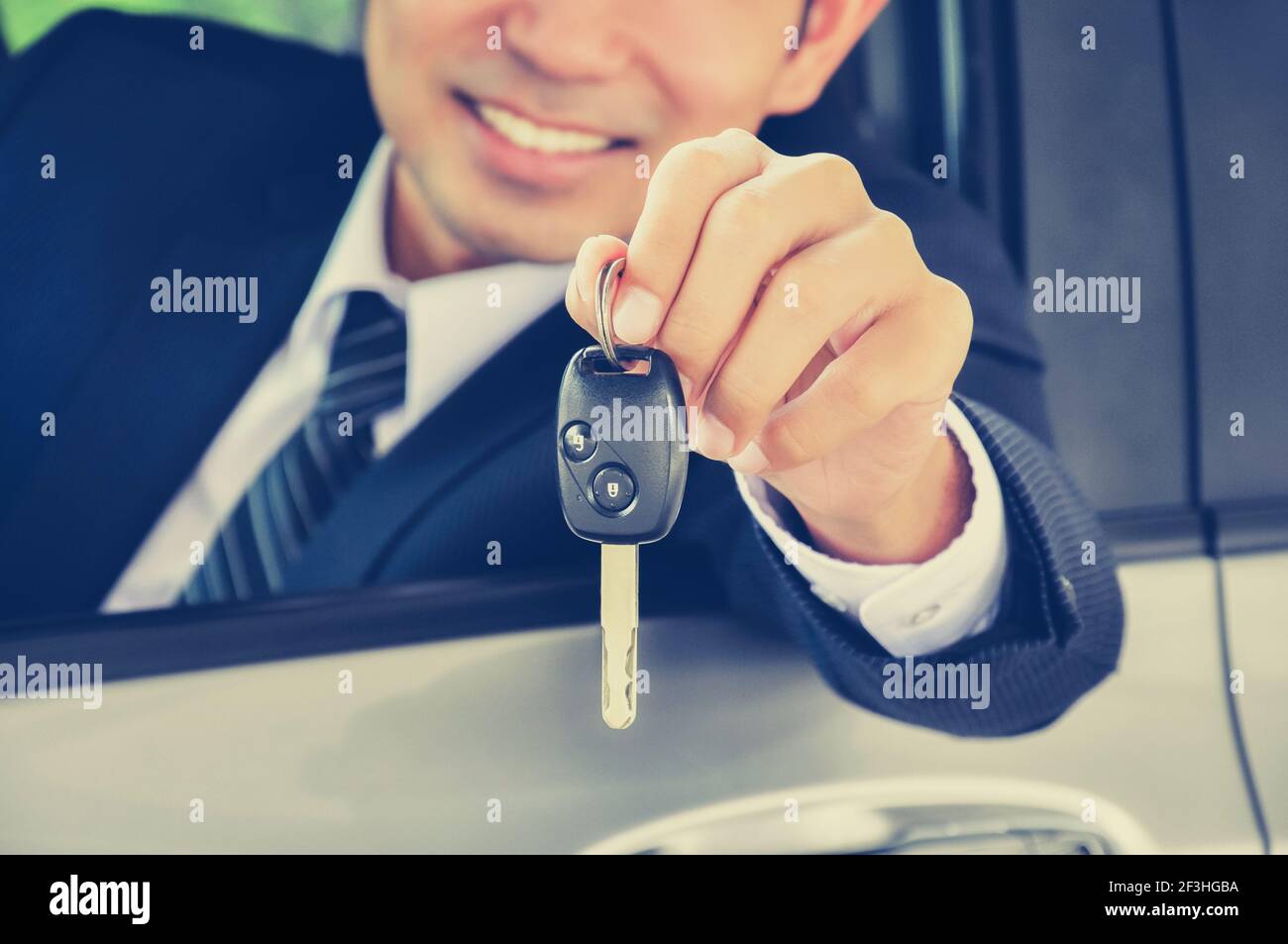 Homme d'affaires donnant une clé de voiture - effet de couleur de style vintage Banque D'Images