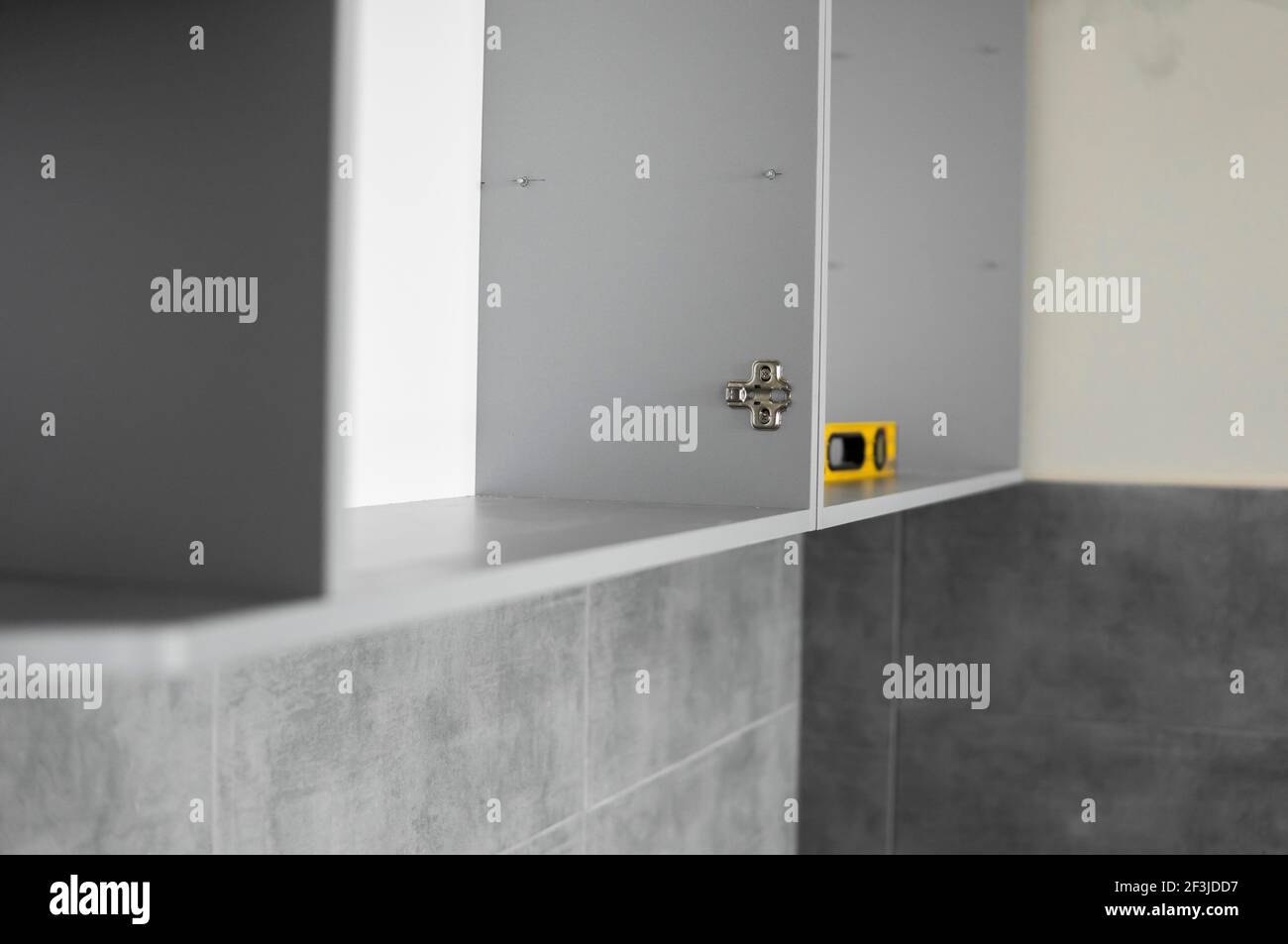 Détails des armoires de cuisine personnalisées. Cuisine modulaire grise en carton sur une variété d'étapes d'installation dans la cuisine avec un carrelage gris Banque D'Images