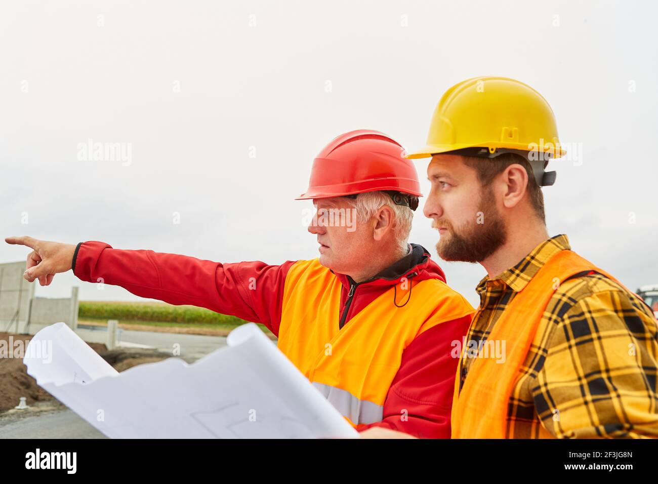 Architecte et contremaître avec dessin de construction pour le développement de un chantier de construction Banque D'Images